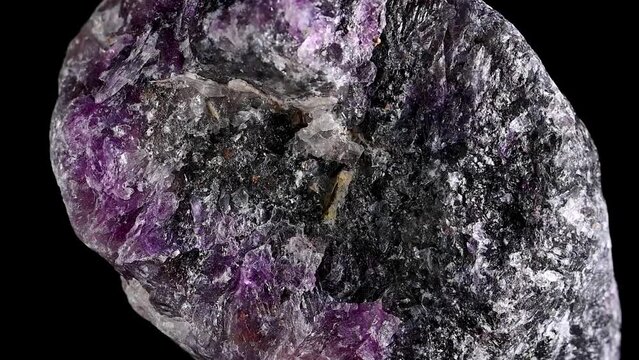 Purple Fluorite sample rotating slowly against a black background.	
