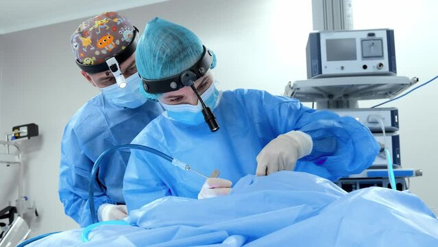 Surgeon and assistant perform laparoscopy surgery 