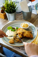 Woman eating fried fish with mashed potatoes and quince apple jam