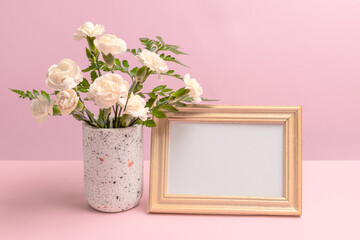 Bouquet of carnations in a vase with a photo frame.