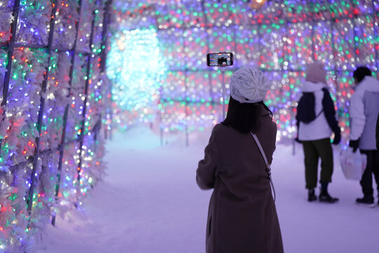 people in the city walk in illumination tunnel at toya lake snow winter season at night time