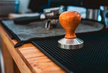 Equipment in a coffee shop of barista coffee tool coffee tamper and  a portafilter on counter in a cafe