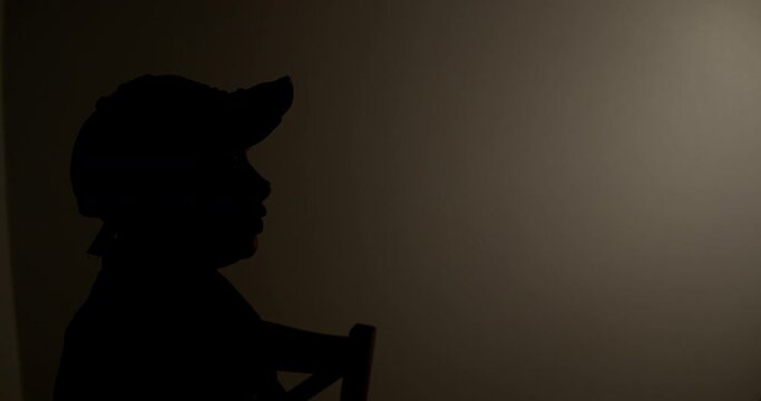 Witness anonymous woman being interviewed in a dark room.