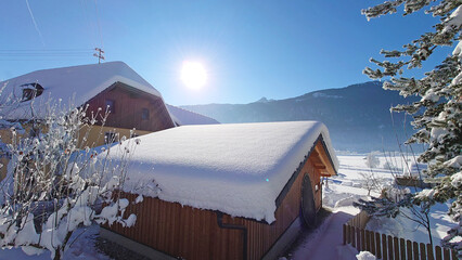 Snow covered house in the mountains of Carinthia, Austria, on a sunny day with a clear blue sky....