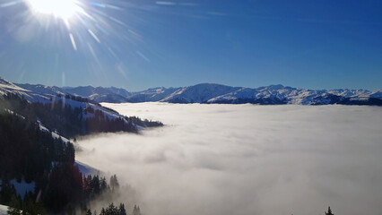 Ski Resort and beautiful sight of alps with lower clouds underneath a clear blue and sunny sky....