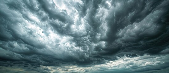 A grey storm cloud blankets the wide sky above a beach, creating a dramatic scene.