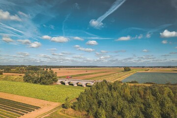A captivating view from high above showcases a lush farm sprawling across rolling hills, with a...