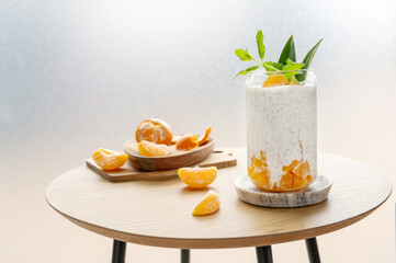 Pudding from chia seeds and yogurt or milk with clementine on the small table.