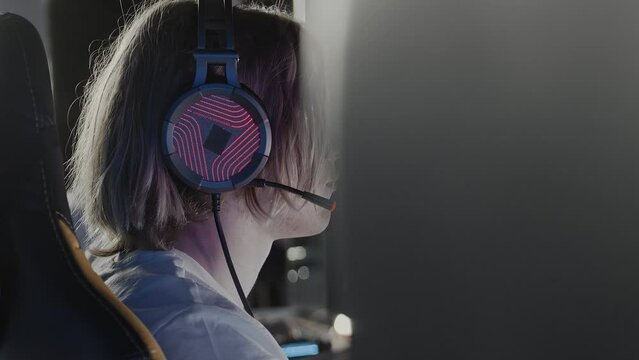 Serious focused teen gamer in headset playing PC video game at computer club during cyber sport tournament. E-sport championship. Modern multiplayer online real-time strategy RTS, tactics skill