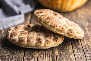 Arabic flat pita bread on wooden table.