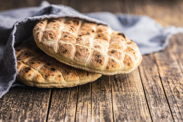 Arabic flat pita bread on wooden table.