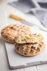 Arabic flat pita bread on white table.
