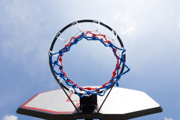Basketballkorb mit Ball vor blauem Himmel
