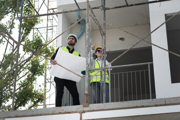 Middle east  engineer man and woman working with tablet computer and paper work in building at construction site	