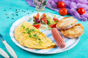 Fried omelette with sausage and salad. Delicious breakfast with eggs and toast