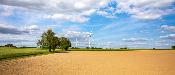 Paysage de campagne en France et ses éoliennes au milieu des champs.