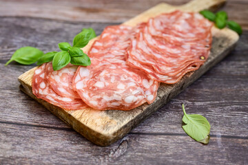 Slices Of  Traditional Italian  dried thinly sliced   artisan  pork salami Milano .Antipasti  salami on a wooden  cutting board © Striker777