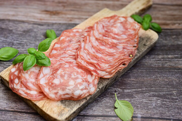 Slices Of  Traditional Italian  dried thinly sliced   artisan  pork salami Milano .Antipasti  salami on a wooden  cutting board © Striker777