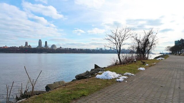  Clear blue skies over the modern skyline of Upper Manhattan, viewed from the serene shores of Edgewater, NJ.