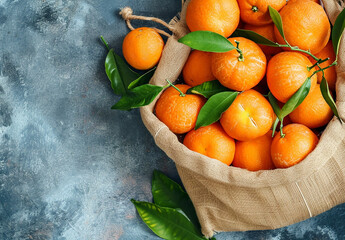 Fresh tangerines, clementines with leaves on dark background. Top view, copy space.