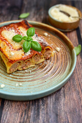 Cannelloni bolognese and parmesan cheese  on a wooden rustic  background.Home made italian meal
