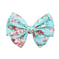 Turquoise hair bow with floral pattern. Stylish accessory for fashion projects.