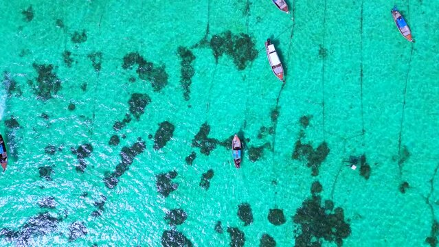 longtail boats in turquoise ocean on beach. Amazing aerial top view flight drone