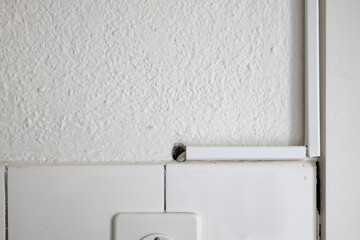 White plastic electric cable duct covers on a kitchen wall. Close up shot, no people
