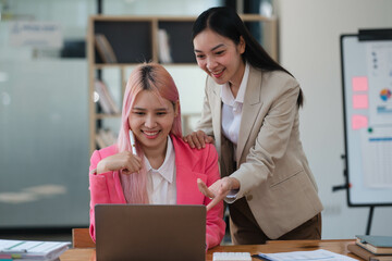 Two businesswomen working together at a boardroom during a meeting in a modern office.