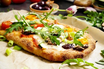 Homemade vegetarian Pinsa with tomato, olive, arugula and mozzarella - 743852765