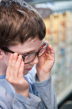 Young boy trying on different frames for new glasses