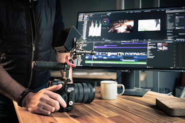 Photographe vidéaste créatif devant un ordinateur en train de faire du montage et de la post-production dans un studio