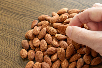 山盛りのアーモンドから一粒指でつまみ上げる