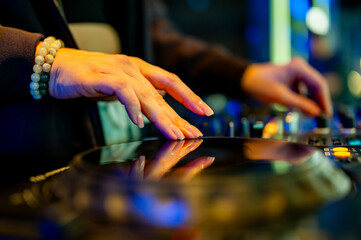woman DJ Hands creating and regulating music on dj console mixer in concert