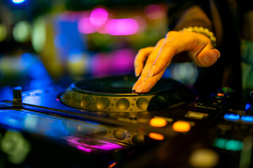 woman DJ Hands creating and regulating music on dj console mixer in concert