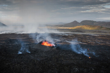 Apocalyptic surroundings of an erupted volcano, red hot lava boiling and pouring down the crater,...