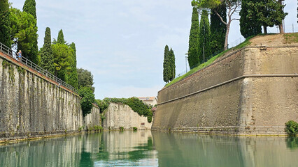 Historical landmark in Italy, the Bastione Caltarane near the Lake of Garda. Historical architecture surrounding the Porta Brescia. Picture taken during a boat trip trough the historic canals.
