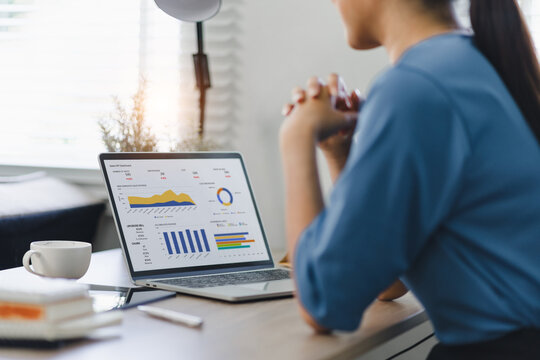 Businesswoman or accountant analyzing data charts, graphs, and dashboard on laptop screen to increase sales and revenue. Business data analytics concept.