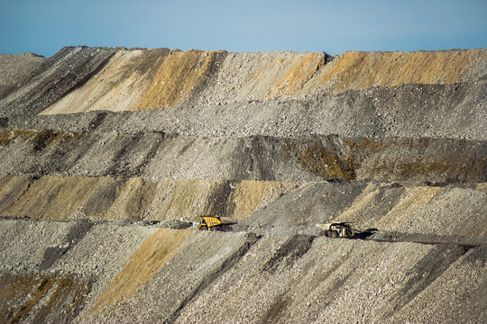Distant mining dump truck transporting tailings through slag heaps