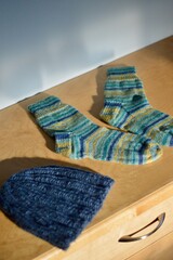 Homemade knitted socks and hat drying in the sun