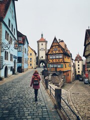 Obraz premium Beautiful view of the historic town of Rothenburg ob der Tauber. Franconia, Bavaria, Germany. Traveler girl standing from behind view
