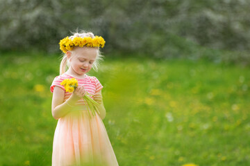 Fair-haired child girl in field of yellow dandelions. Little lady in pink dress holds flowers. Selective focus.