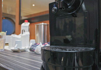 Close up view of Coffee espresso machine maker with cups and glasses on cupboard inside stateroom...