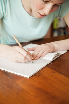 Teen girl doing math work on the table at home