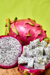 Obraz na płótnie Canvas Red dragon fruit Set with appetizing serving on green background. Top view