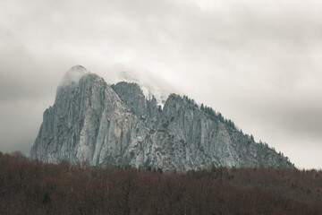 Mountain peak in the snow and clouds with forest under it, Tjentiste, Bosnia and Hercegovina