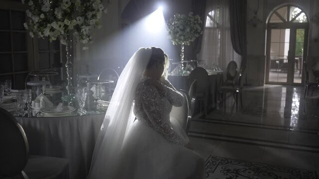 Bride in wedding dress dancing in dark room under flash photography at midnight