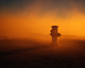 Fire hydrant supply on cracked tarmac street in mist at sunset. - 743908134