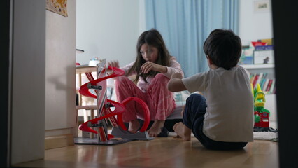 Brother and Sister Collaboratively Playing with Parking Lot Toy, Candid Bedroom Scene