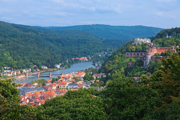 Fototapeta na wymiar Heidelberg, Germany. High angle view from a slope of Konigstuhl hill over Heidelberg Old Town, Neckar river and Odenwald mountains.